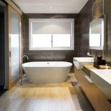 Australian Luxury bathroom with brown tiles and hardwood floor, focusing on a free standing bath. Clipping path around the windows and reflections in mirror/door.